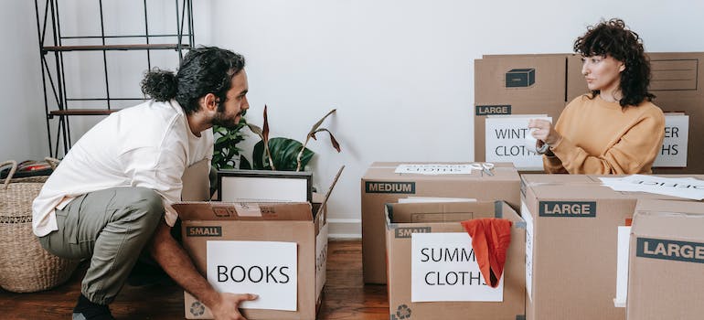 a couple packing boxes before movers Lachine offers come